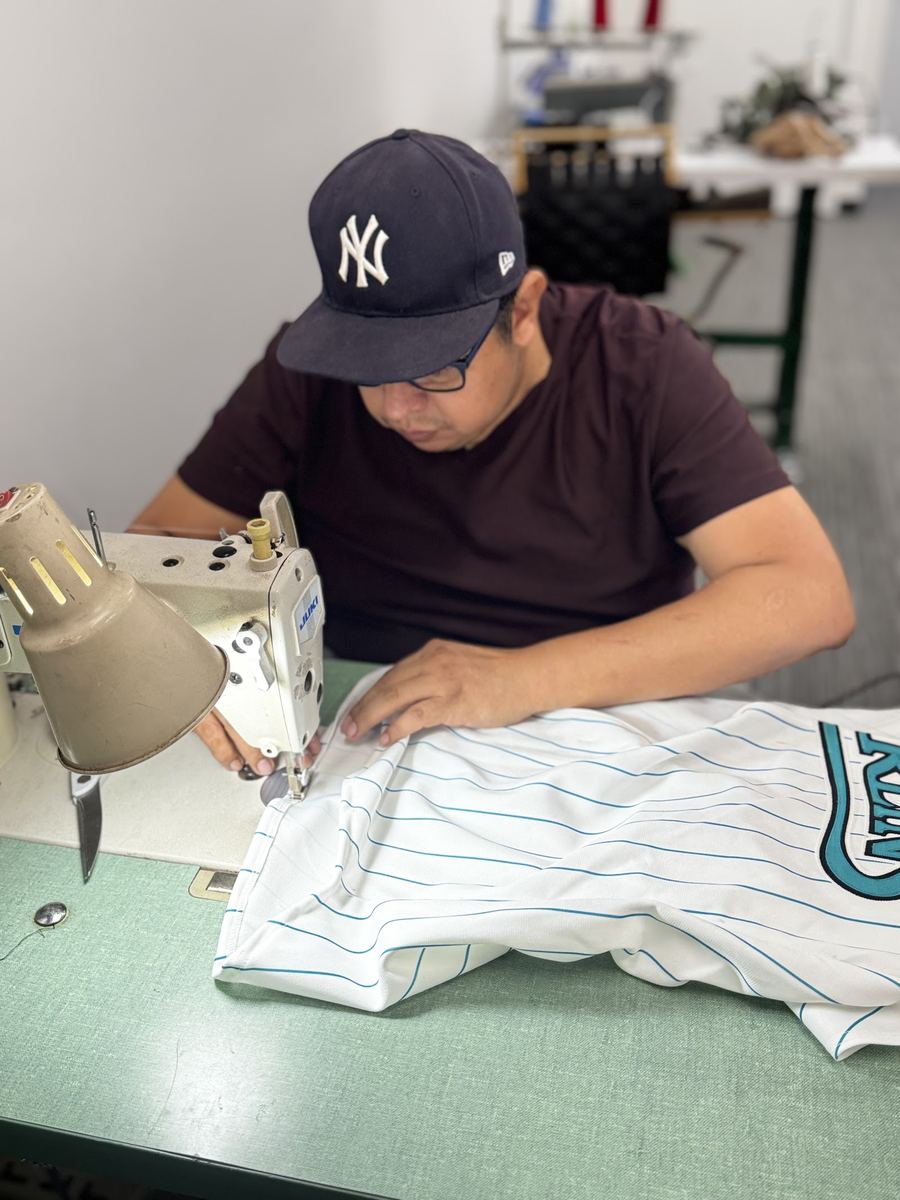 Efrain sewing a jersey